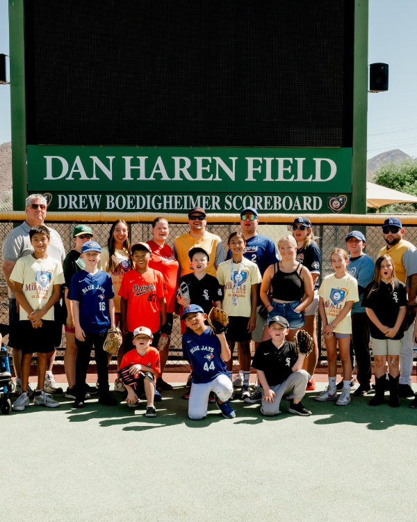 A group of kids in baseball jerseys posing together for a team photo at Dan Haren Field. Featured in Scottsdale Lifestyle Magazine.